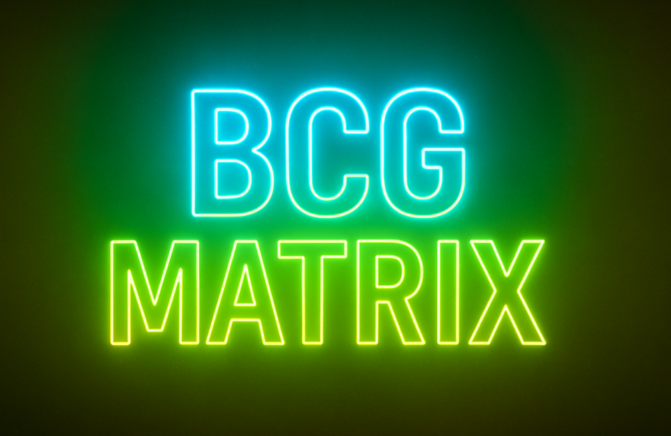Neon sign displaying the words “BCG MATRIX” in cyan and yellow-green on a dark background